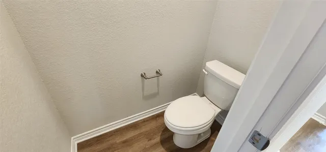 a white toilet sitting next to a wooden cabinet