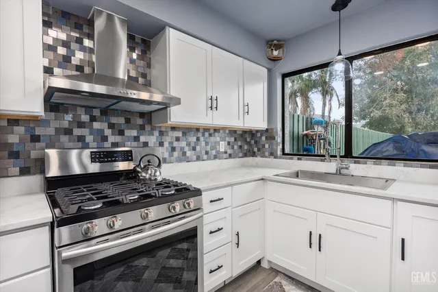 a kitchen with appliances cabinets and a large window