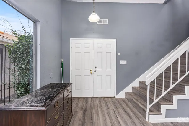 a view of a hallway with wooden floor and staircase