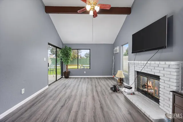 a view of an empty room with a fireplace and a window