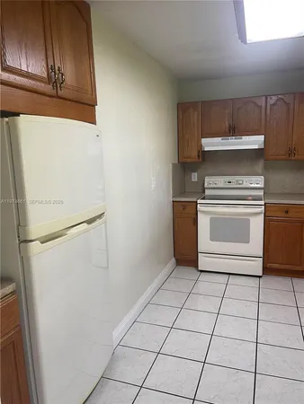a kitchen with a stove top oven and cabinets