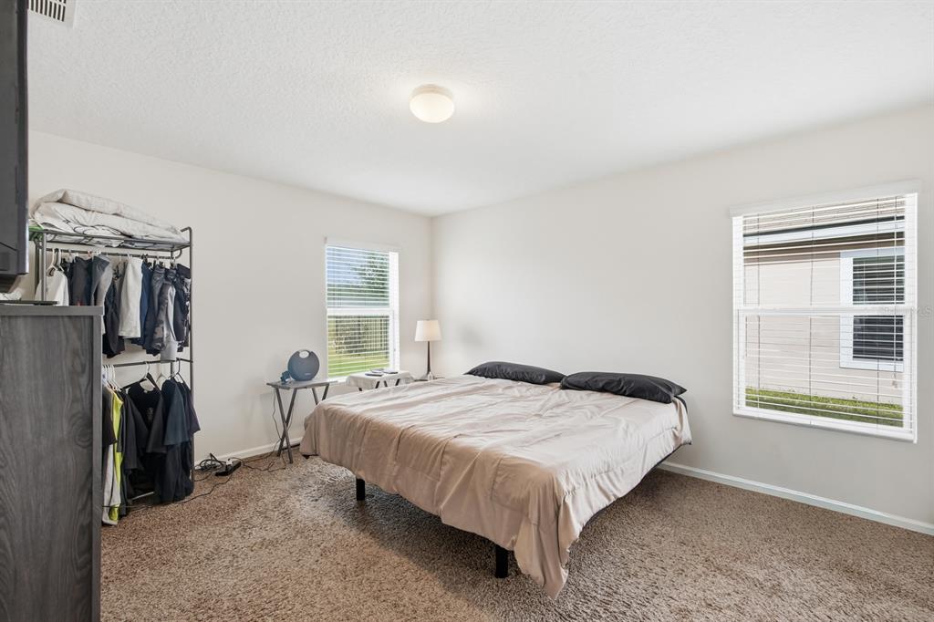 123 Fairway Court Bunnell, FL 32110 - Photo 11 of 22 a bedroom with a bed a flat screen tv and a window