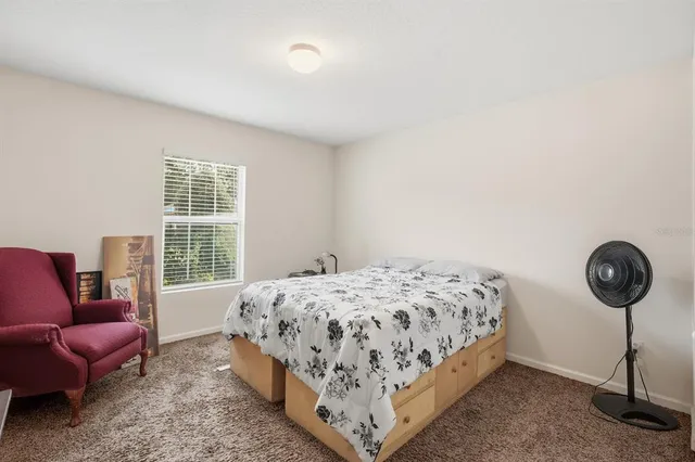 a bedroom with a bed a couch and a window