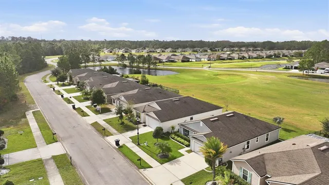 a view of a house with a yard and potted plants