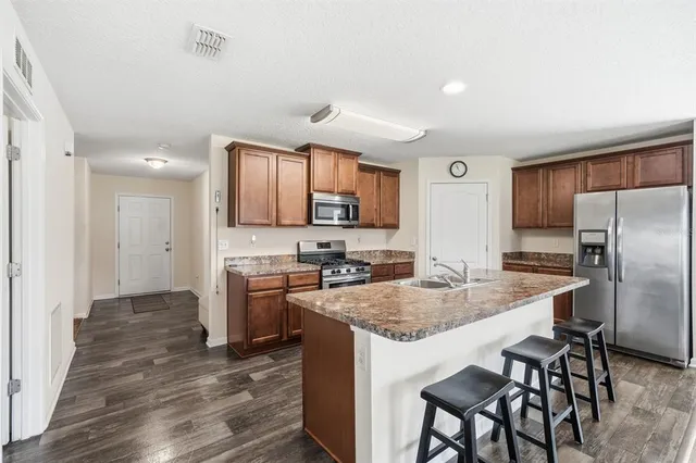 a kitchen with stainless steel appliances granite countertop a stove refrigerator sink and cabinets