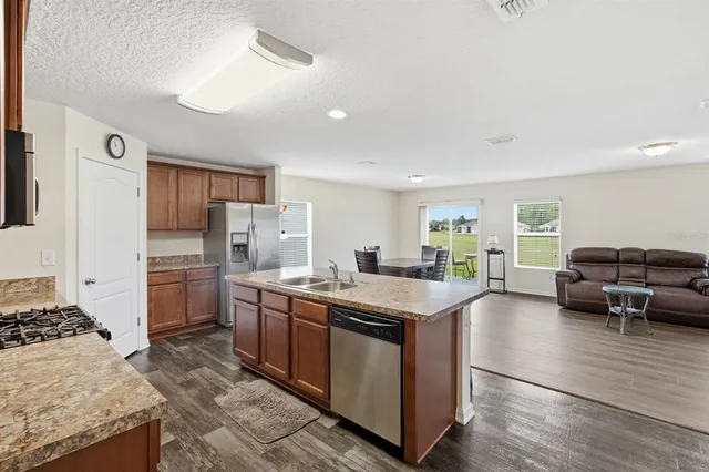a kitchen with kitchen island granite countertop a stove and a refrigerator