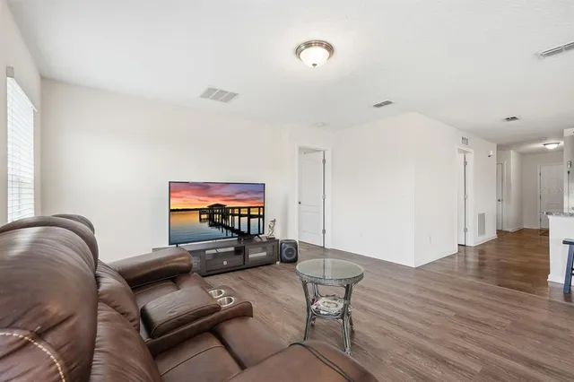 a living room with furniture and wooden floor