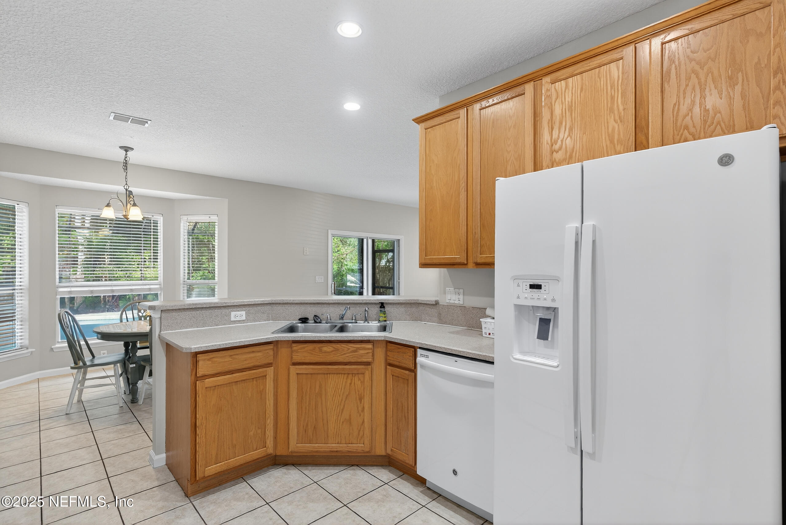 1908 Tuscan Oaks Court Fleming Island, FL 32003 - Photo 11 of 33 a kitchen with a sink a stove and refrigerator