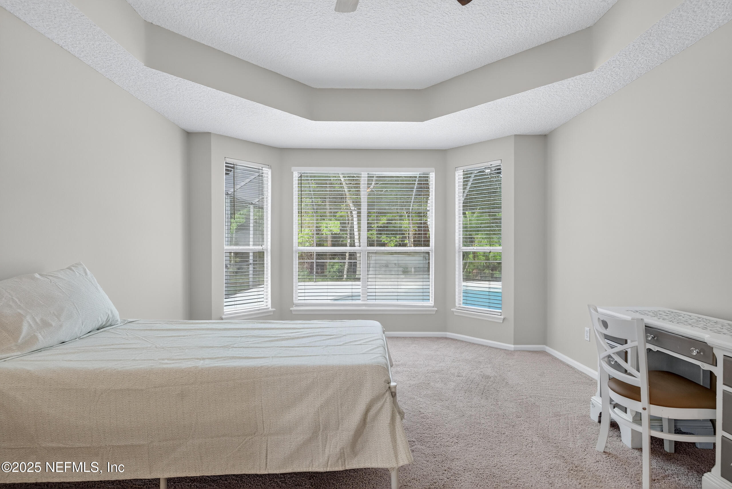 1908 Tuscan Oaks Court Fleming Island, FL 32003 - Photo 18 of 33 a bedroom with a bed and a large window