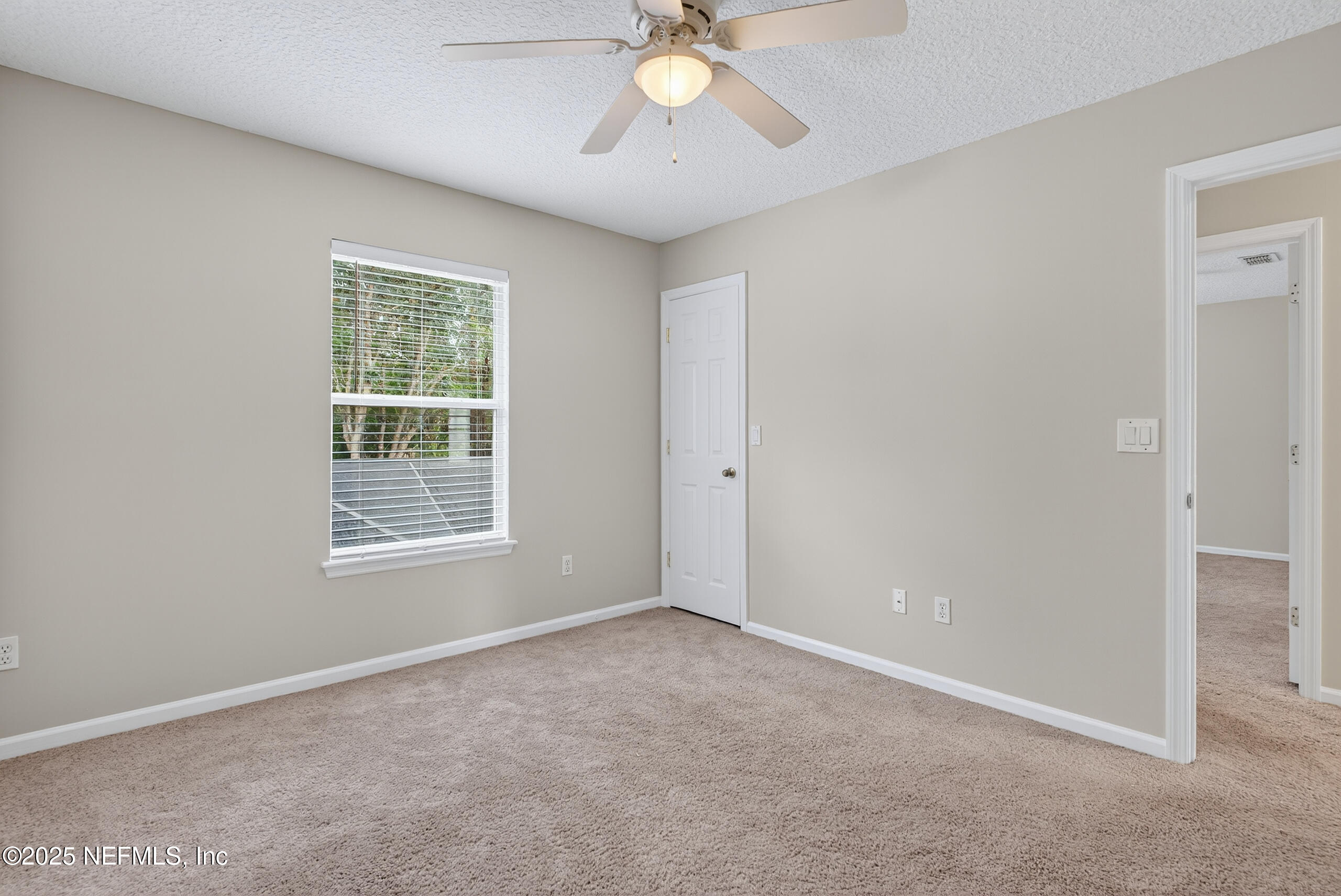 1908 Tuscan Oaks Court Fleming Island, FL 32003 - Photo 23 of 33 an empty room with chandelier fan and windows