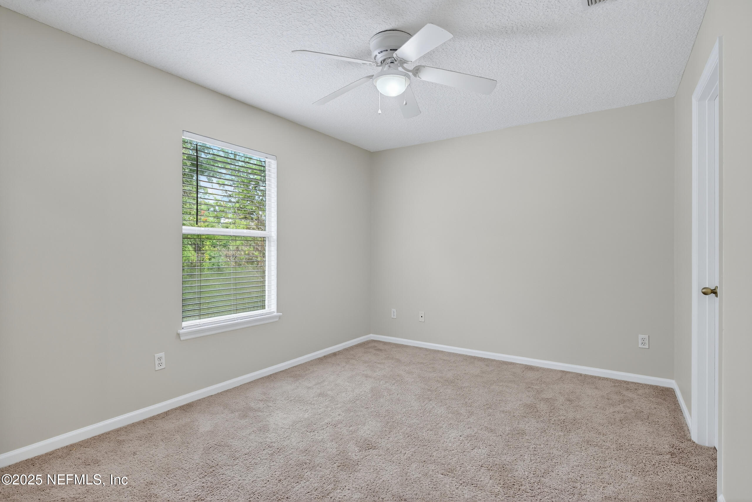 1908 Tuscan Oaks Court Fleming Island, FL 32003 - Photo 25 of 33 an empty room with a window and a fan