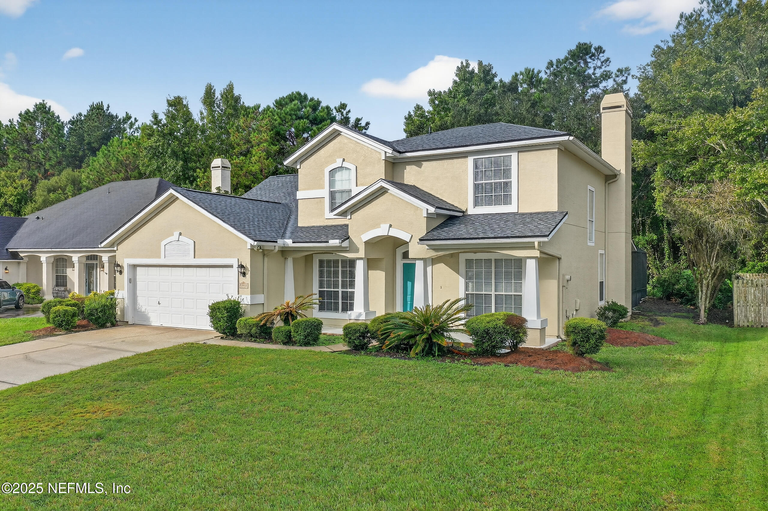 1908 Tuscan Oaks Court Fleming Island, FL 32003 - Photo 4 of 33 a front view of a house with a garden and plants