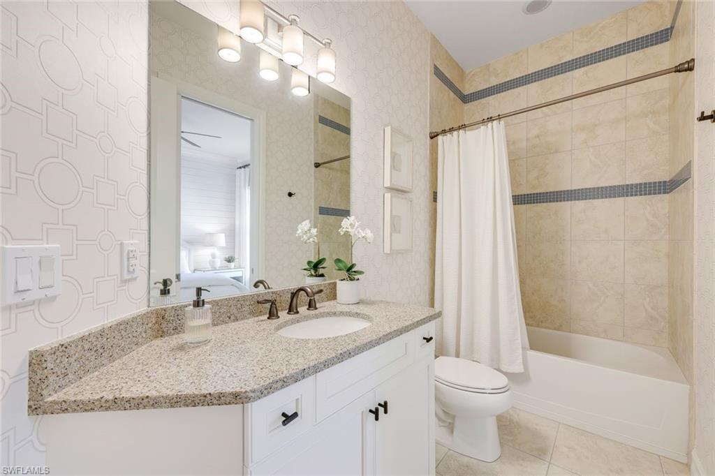6573 Roma Way Naples, FL 34113 - Photo 23 of 49 Full bathroom featuring tile patterned flooring, vanity, shower / bath combination with curtain, and toilet