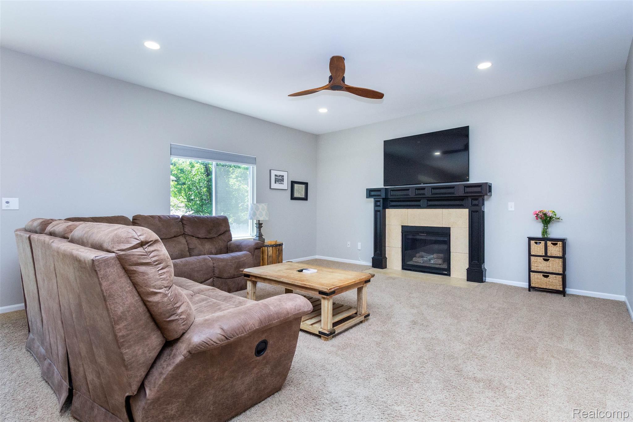 36039 Curtis Road Livonia, MI 48152 - Photo 8 of 61 Living area featuring a fireplace with a black mantel and light-toned surround, recessed lighting, a ceiling fan, and carpeted flooring