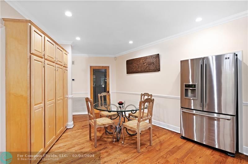 1129 Southwest 2nd Street Boca Raton, FL 33486 - Photo 6 of 39 a kitchen with stainless steel appliances a refrigerator a microwave a dining table and chairs with wooden floor