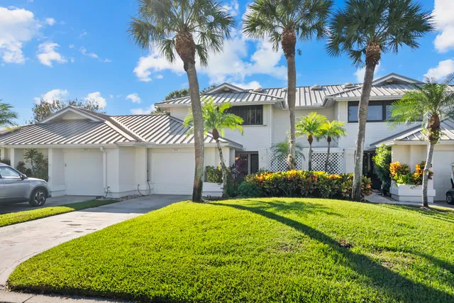 a front view of a house with a garden and yard
