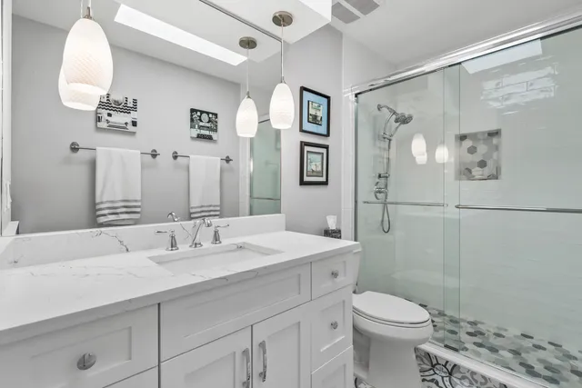 an open kitchen with stainless steel appliances kitchen island granite countertop a table chairs in it and wooden floors