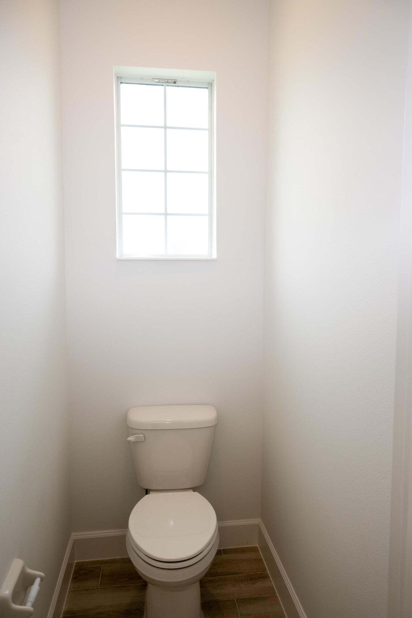 7809 Cache Crk Lane Melbourne, FL 32940 - Photo 12 of 35 a white toilet sitting in a bathroom next to a window