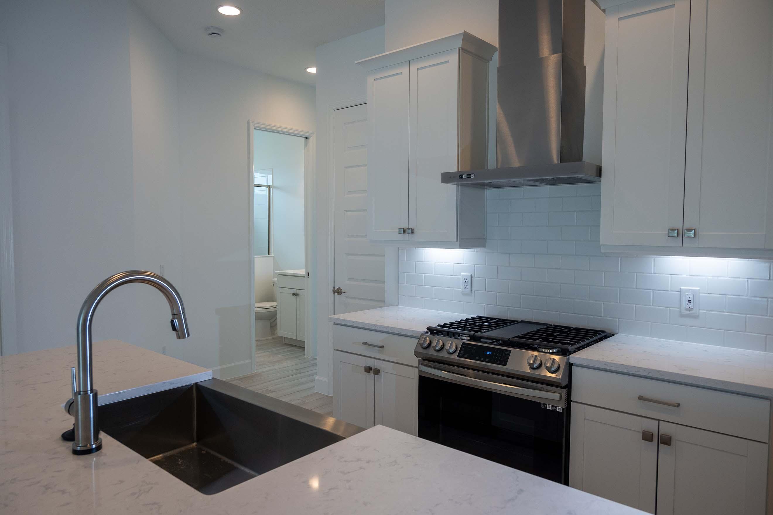 7809 Cache Crk Lane Melbourne, FL 32940 - Photo 5 of 35 a kitchen with stainless steel appliances a stove a sink and a microwave