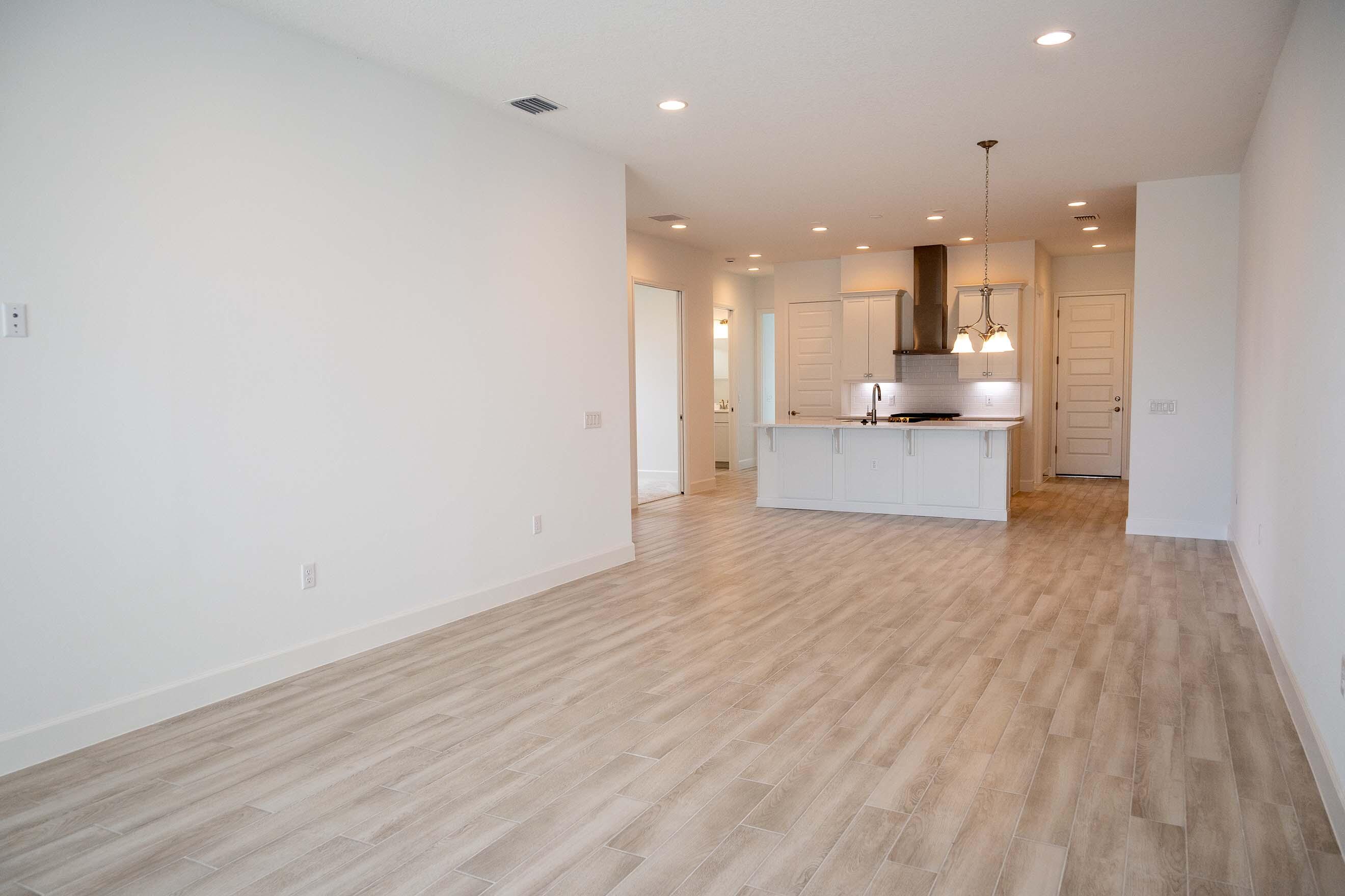 7809 Cache Crk Lane Melbourne, FL 32940 - Photo 7 of 35 a view of a kitchen with kitchen island a sink wooden floor and a large window