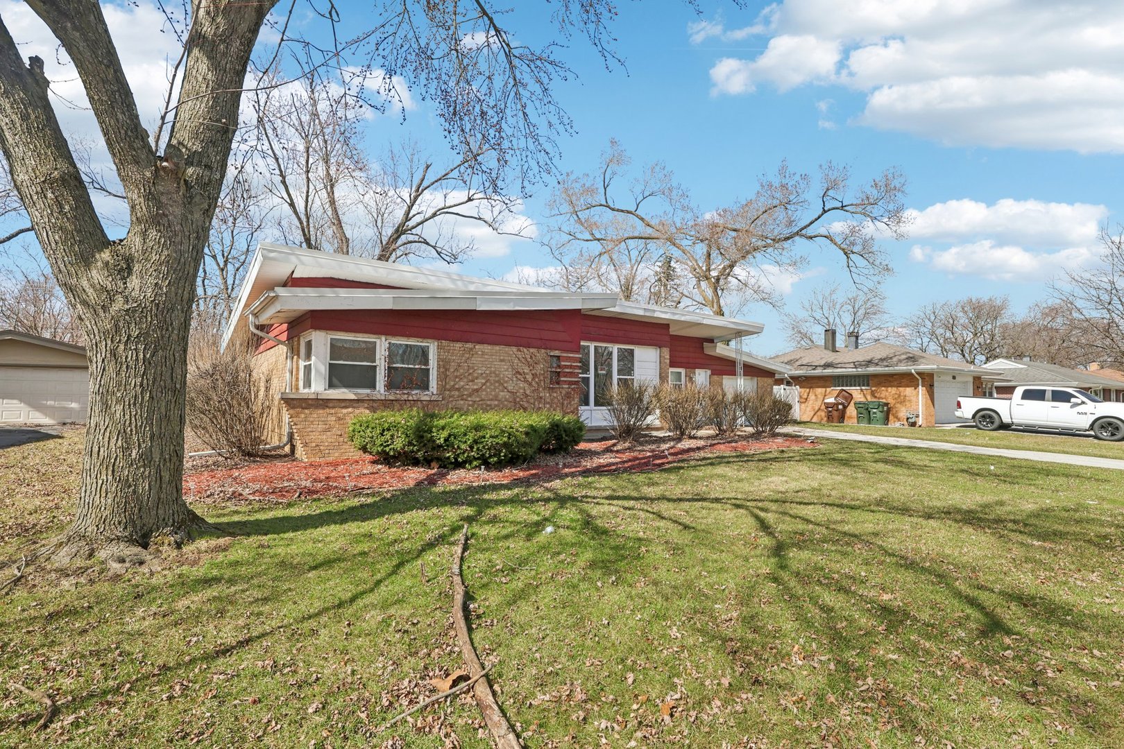a front view of house with yard and trees in the background