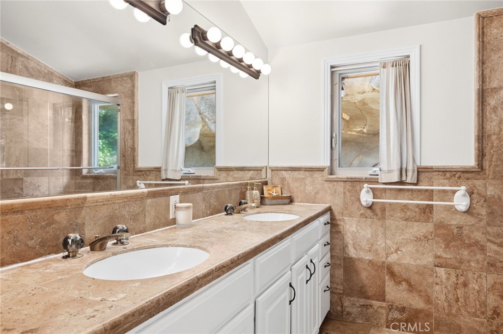 2072 Hidden Valley Canyon Road Laguna Beach, CA 92651 - Photo 13 of 26 a bathroom with a granite countertop sink and a mirror