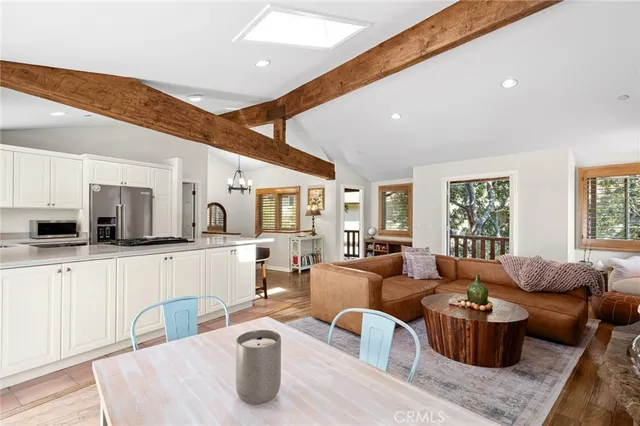 a living room with furniture a large window and kitchen view