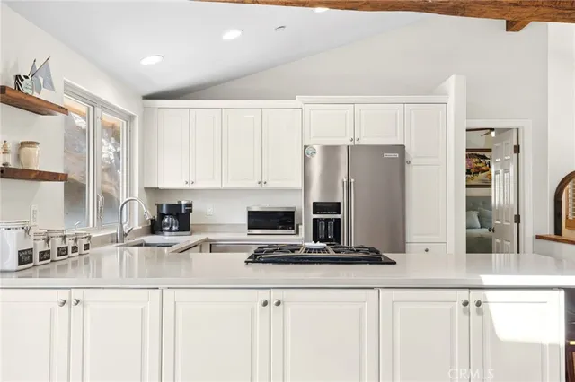 a kitchen with stainless steel appliances granite countertop a sink and a refrigerator
