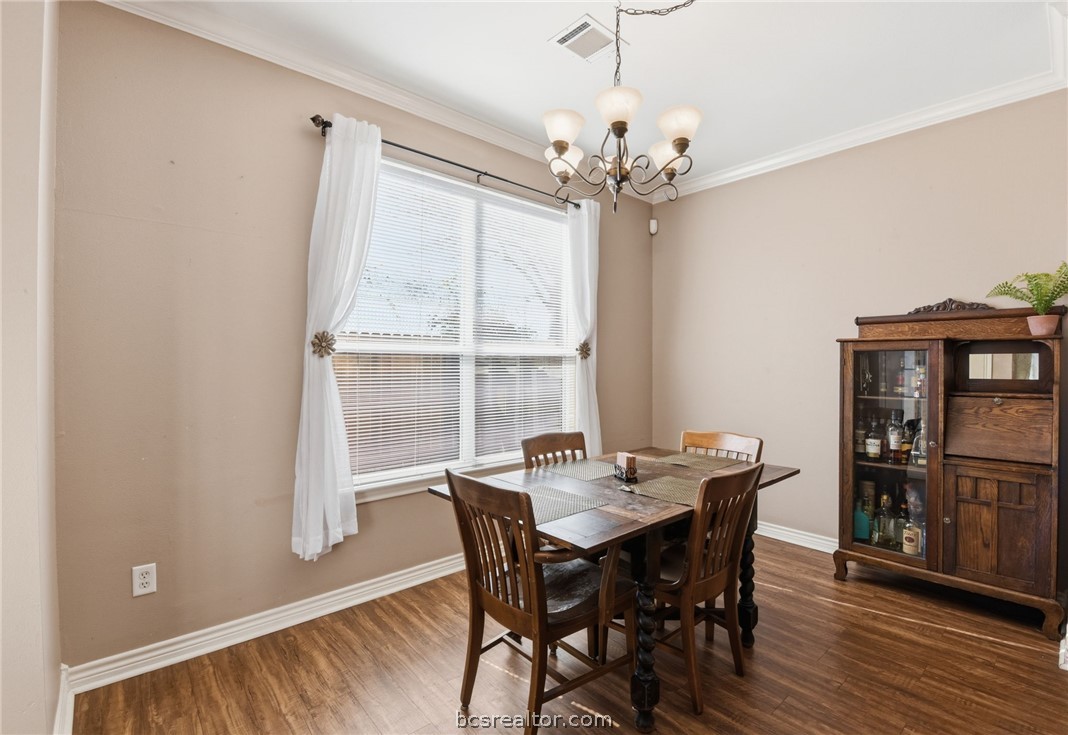 1425 West Villa Maria Road, Unit 605 Bryan, TX 77801 - Photo 12 of 46 Dining area with dark wood-style flooring, hanging lights, and ornamental molding