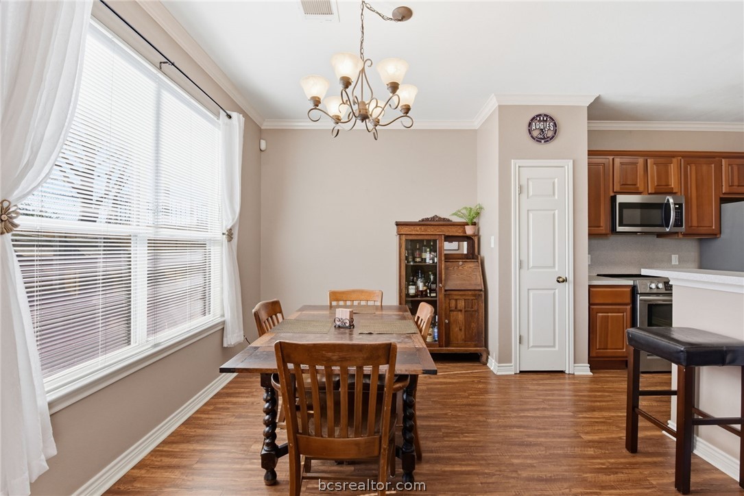 1425 West Villa Maria Road, Unit 605 Bryan, TX 77801 - Photo 13 of 46 Dining room with dark wood-style flooring, hanging lights, and crown molding