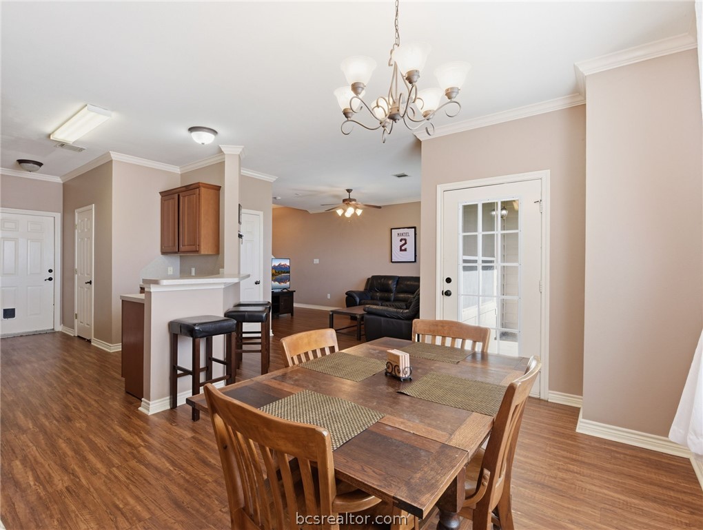 1425 West Villa Maria Road, Unit 605 Bryan, TX 77801 - Photo 15 of 46 Dining room featuring crown molding, ceiling fan, dark wood-style flooring, and hanging lights
