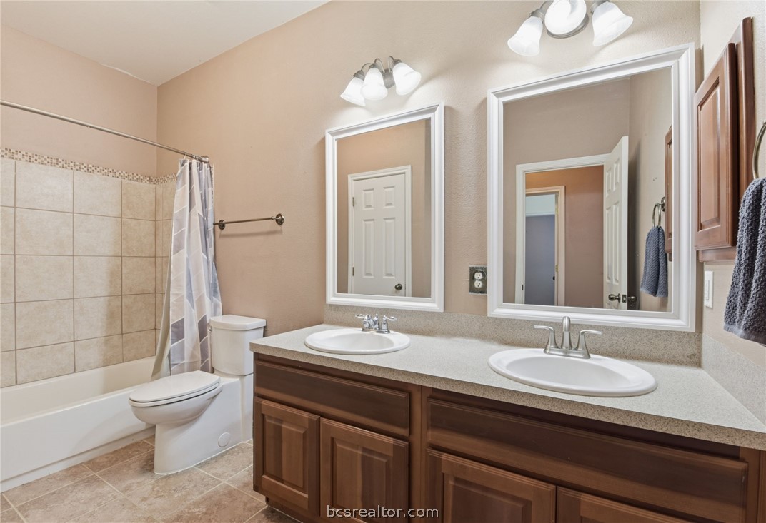 1425 West Villa Maria Road, Unit 605 Bryan, TX 77801 - Photo 28 of 46 Full bath with double vanity, shower / bath combo with shower curtain, and light tile patterned floors