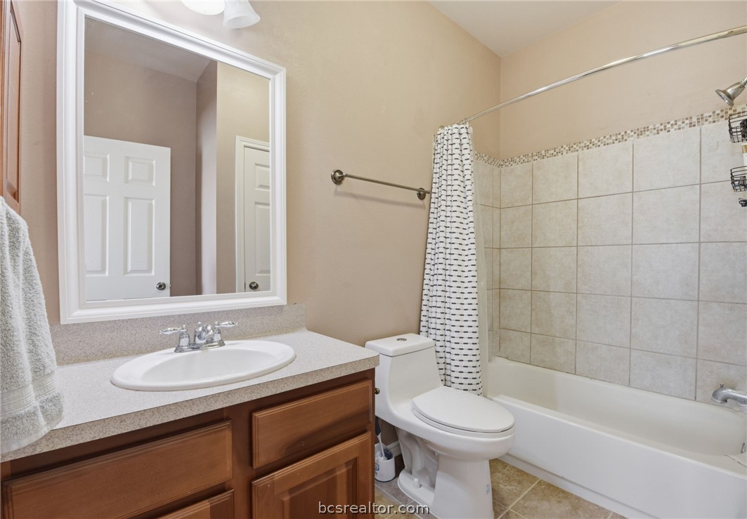 1425 West Villa Maria Road, Unit 605 Bryan, TX 77801 - Photo 35 of 46 Bathroom featuring vanity, shower / bathtub combination with curtain, and light tile patterned flooring