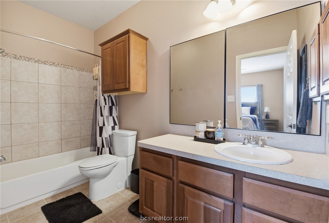1425 West Villa Maria Road, Unit 605 Bryan, TX 77801 - Photo 39 of 46 Full bath with vanity, ensuite bathroom, shower / bath combo with shower curtain, and light tile patterned flooring