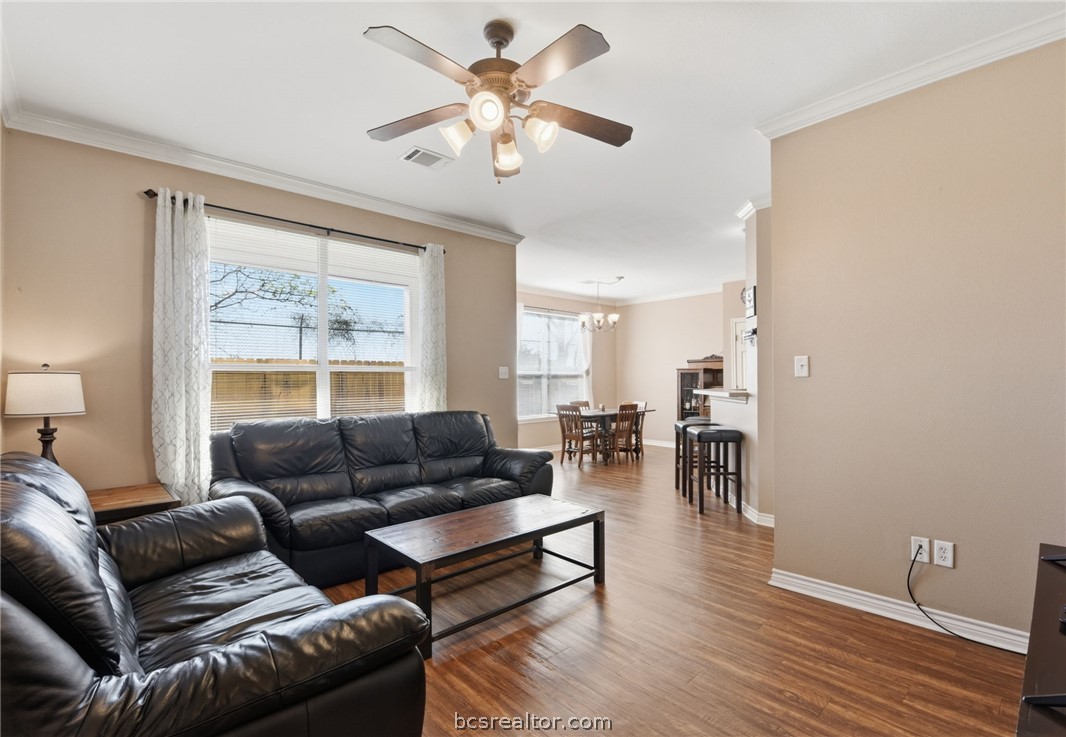 1425 West Villa Maria Road, Unit 605 Bryan, TX 77801 - Photo 8 of 46 Living room with crown molding, dark wood-style flooring, ceiling fan, and suspended lighting