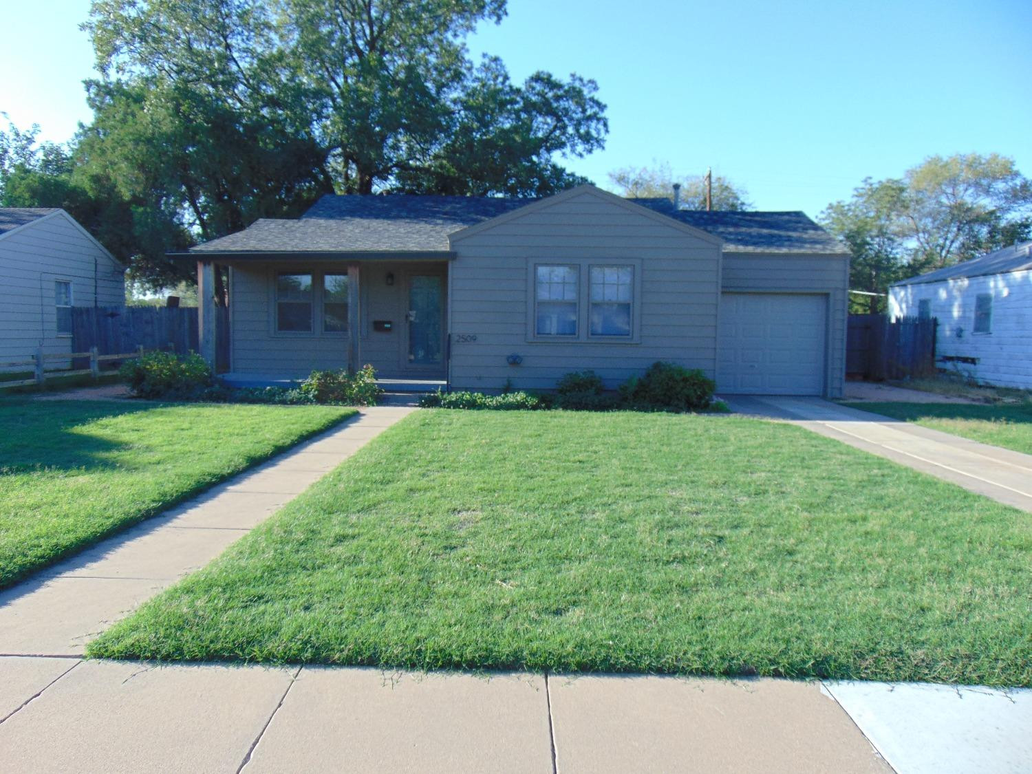 2509 29th Street Lubbock, TX 79410 - Photo 1 of 10 a backyard of a house with plants and large tree