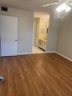 a view of an empty room with wooden floor