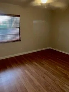 a view of a small space with wooden floor and a window