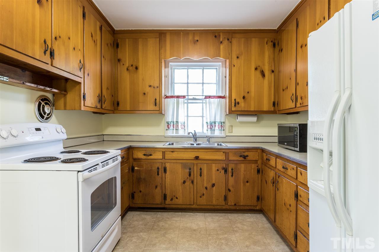 4929 Kaplan Drive Raleigh, NC 27606 - Photo 17 of 30 a kitchen with stainless steel appliances granite countertop a stove a sink and a microwave