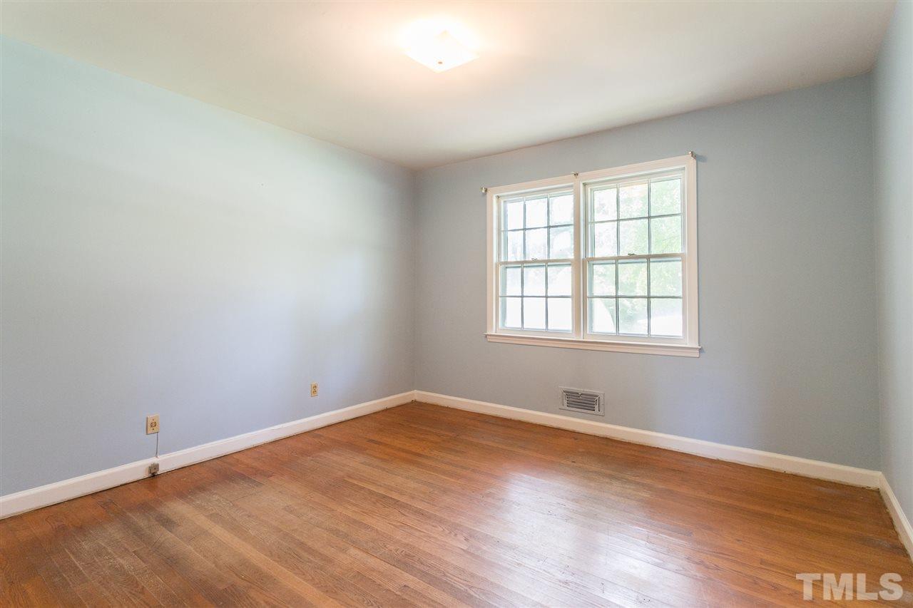 4929 Kaplan Drive Raleigh, NC 27606 - Photo 22 of 30 an empty room with wooden floor and windows