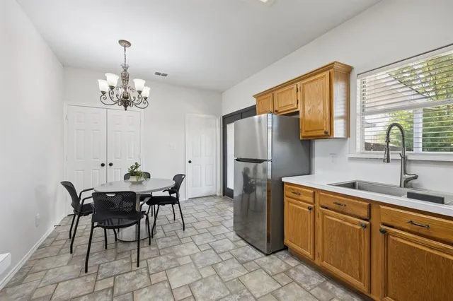 a kitchen with stainless steel appliances a table and chairs in it