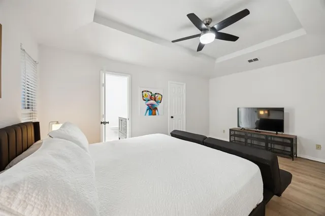 a bedroom with a bed and a flat tv screen on the dresser