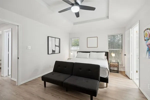 a spacious bedroom with a bed couch and window