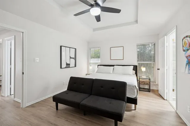 a spacious bedroom with a bed couch and window