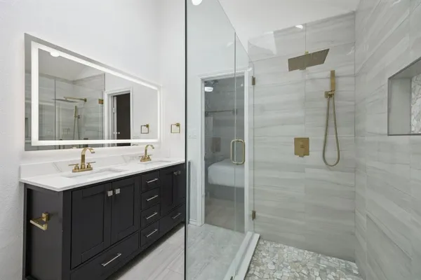 a bathroom with a double vanity sink mirror and shower