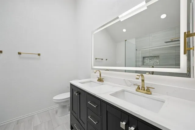 a bathroom with a sink a toilet and a mirror