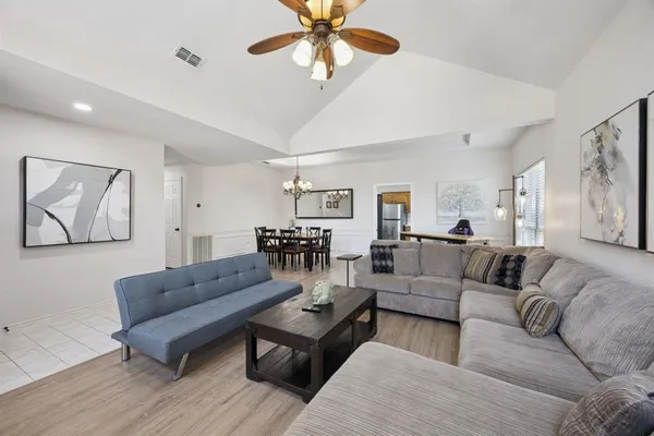 a living room with furniture and a ceiling fan