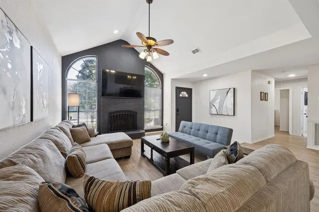 a living room with furniture a flat screen tv and a fireplace