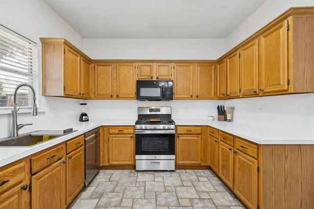 a kitchen with stainless steel appliances granite countertop a sink and a stove