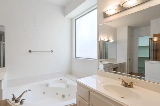 a bathroom with a sink a bathtub and a mirror